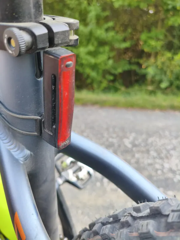 Czerwona lampa pozycyjna Knog Plus zamocowana na rurze podsiodłowej