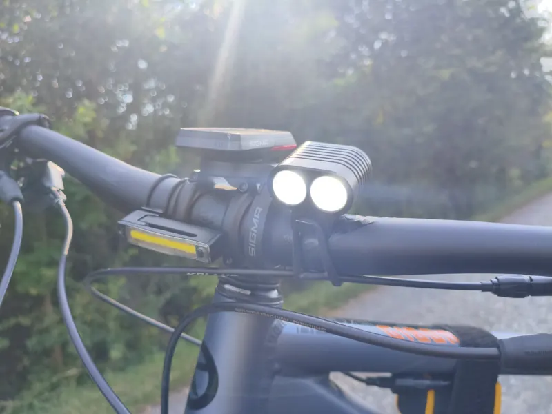 Włączona dwudiodowa lampa ProX Libra, lampa pozycyjna Knog Plus i licznik SIGMA ROX 4.0 na kierownicy